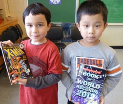 Grade 1 students Matthew and Derek (left to right) proudly display the books they chose to take home with them. “The cover is very cool,” says Matthew. “I think this book is good,” says Derek. Photos by Julie Cheng