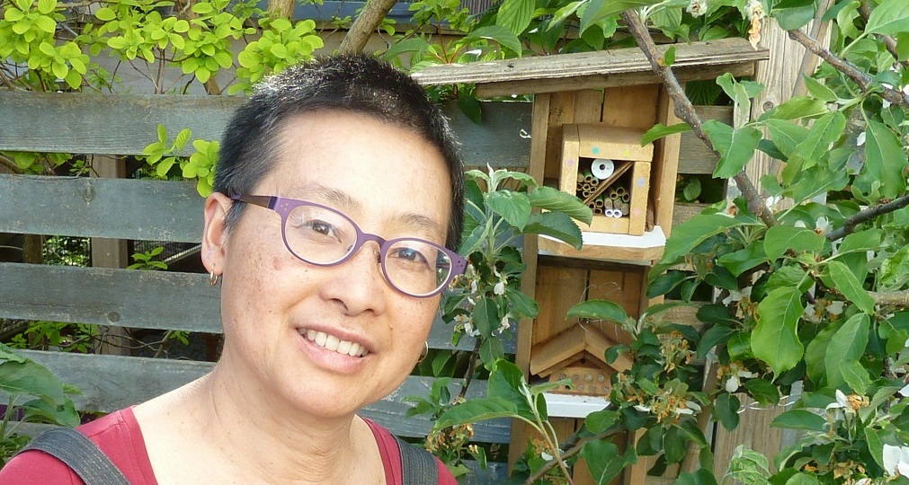 Julie Cheng in the garden with mason bee homes.